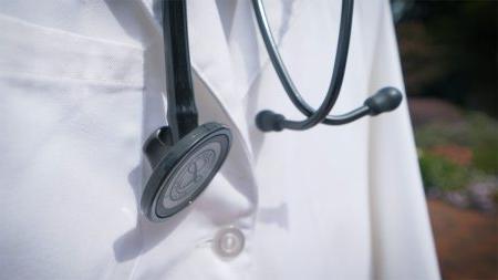 Close up shot of a lab coat and stethoscope.